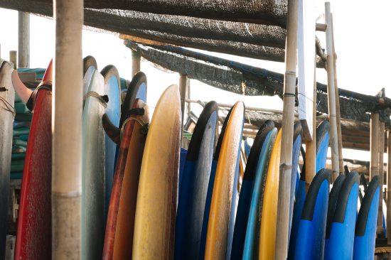 Set Of Different Color Surf Boards In A Stack By Ocean.bali.indo